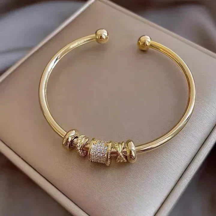 Elegant justerbart armbånd med sofistikerede gyldne charms
